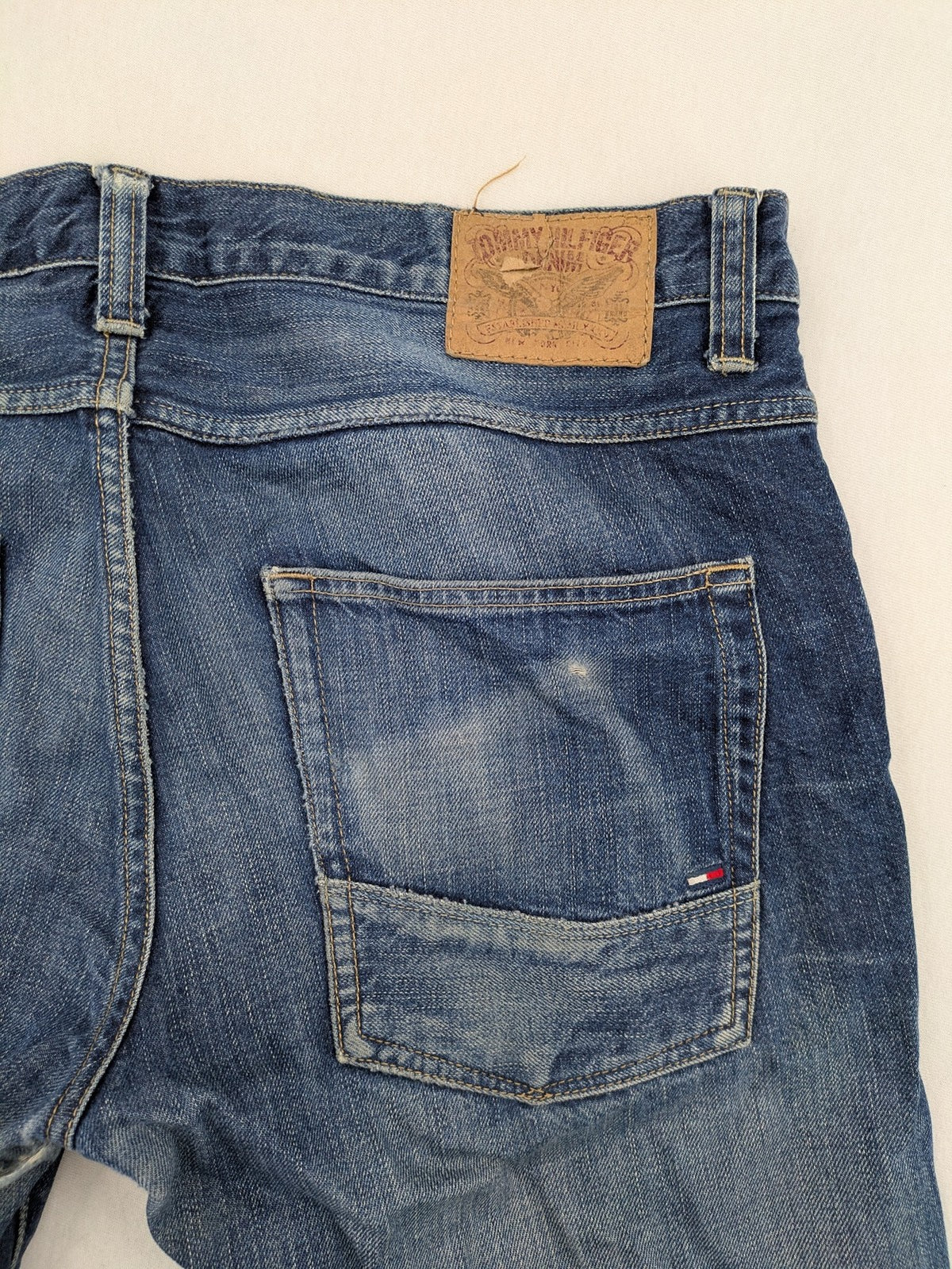 Hilfiger Denim blue straight jeans faded wash with Tommy Hilfiger flag logo on pocket.