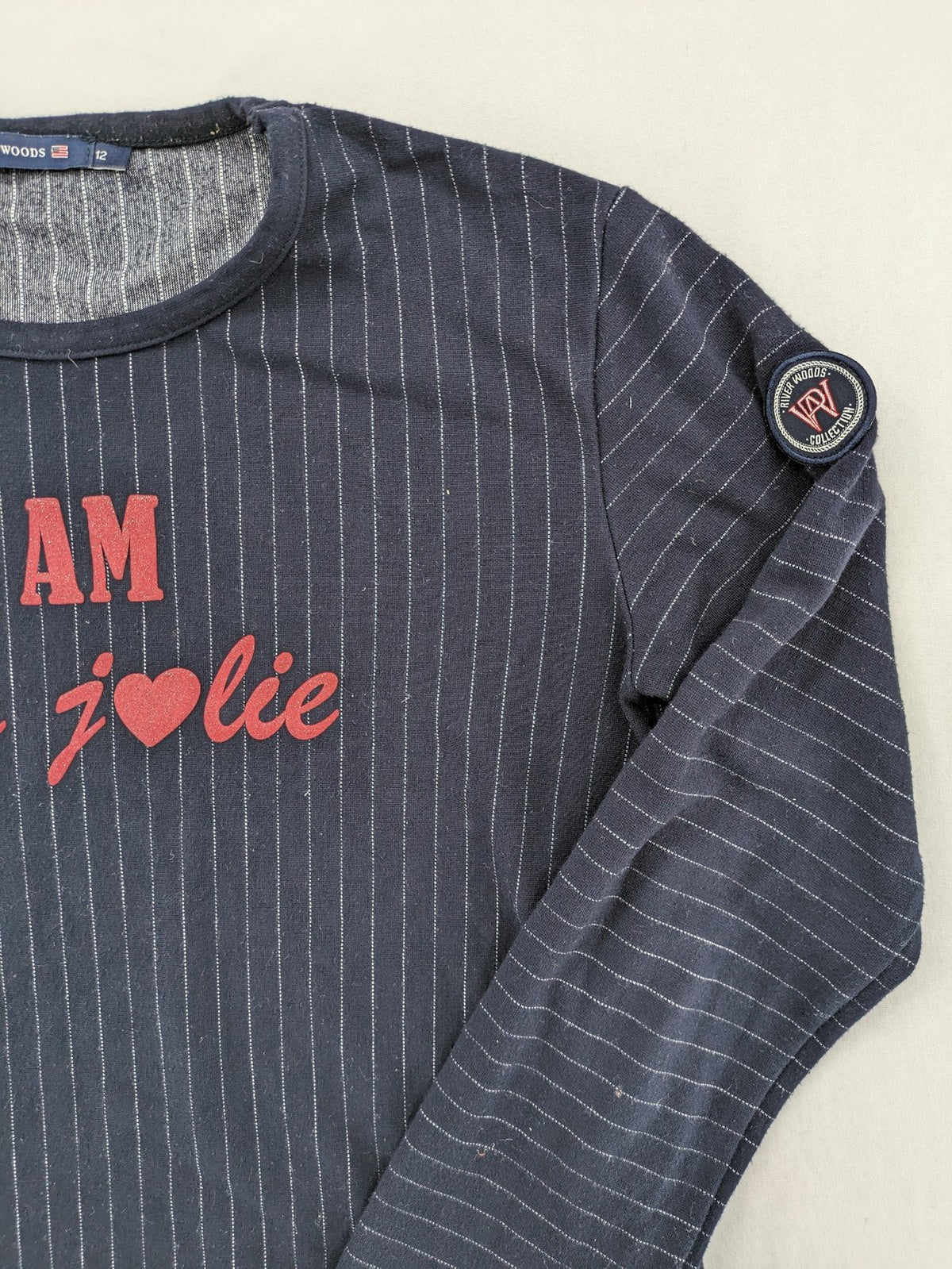 RIVER WOODS navy long sleeve top with white pinstripes and red "I AM très jolie" slogan.