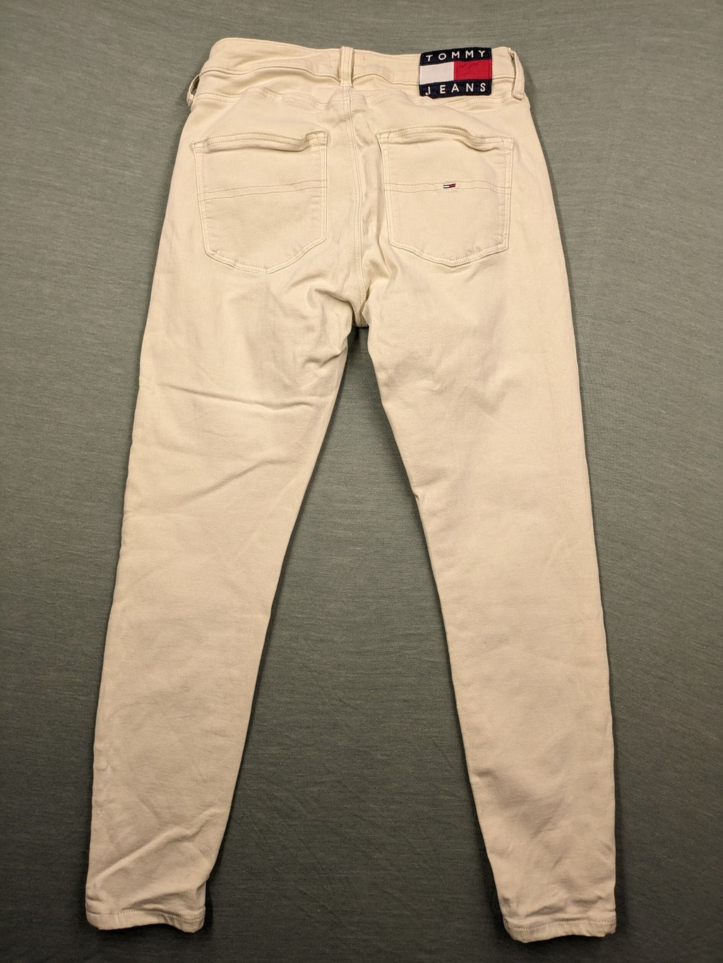 Tommy Jeans beige high rise skinny ankle jeans with logo patch and stretch fabric.