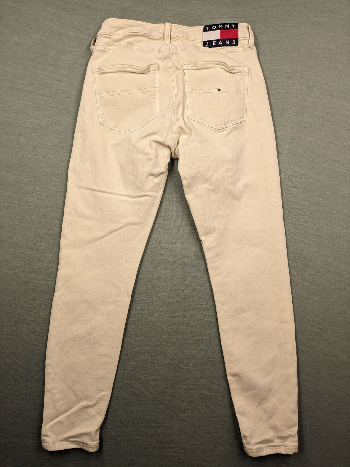 Tommy Jeans beige high rise skinny ankle jeans with logo patch and stretch fabric.