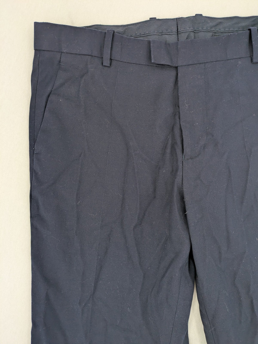 H&M navy slim fit executive suit trousers with flat-front design and side pockets.