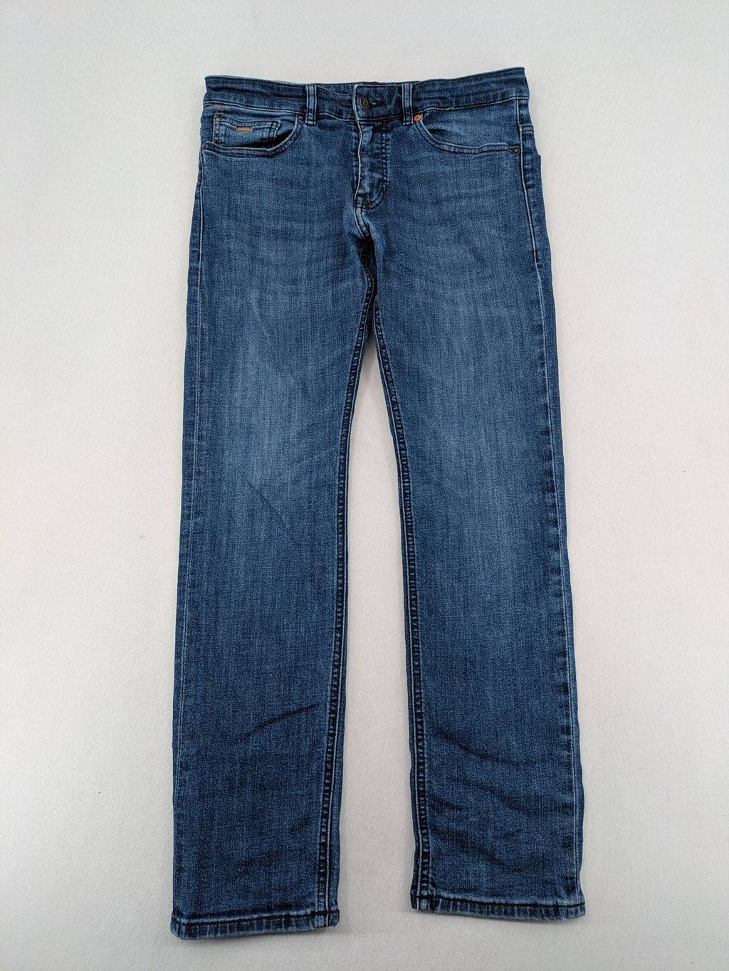 BOSS blue slim fit jeans with logo, five-pocket design, and button fly.