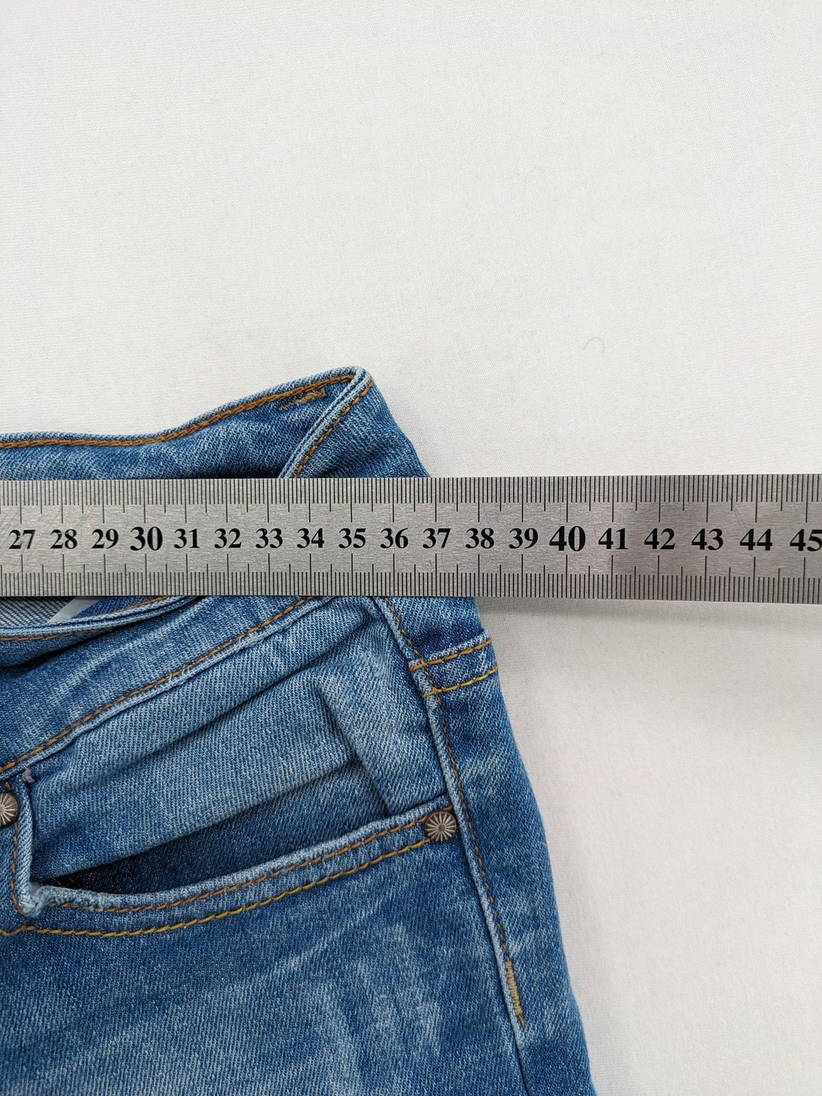 Denim blue straight jeans low rise bootcut with classic 5-pocket design and subtle rivets.
