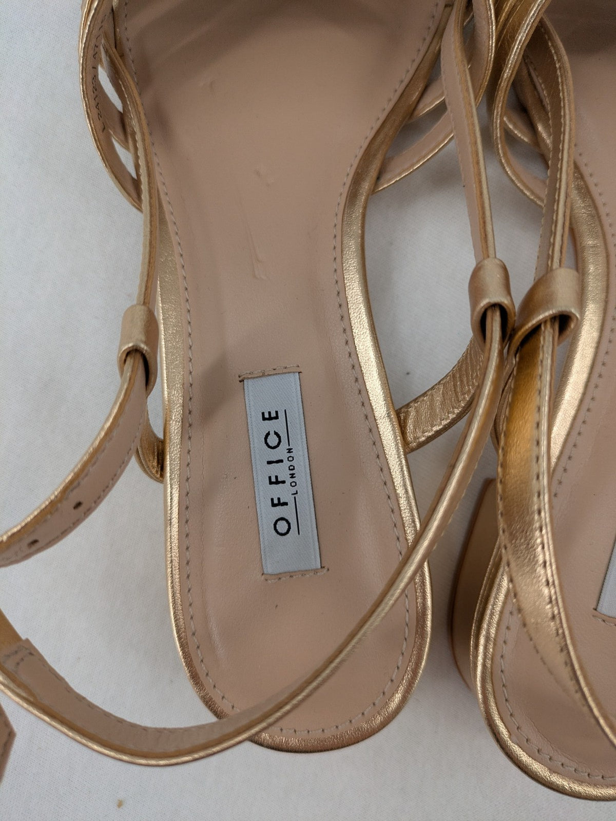 Office London gold metallic sandals with adjustable ankle strap and block heel design.