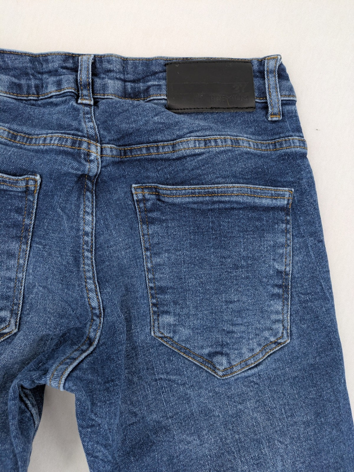 2Y Premium blue skinny jeans with distressed details and classic button fly.