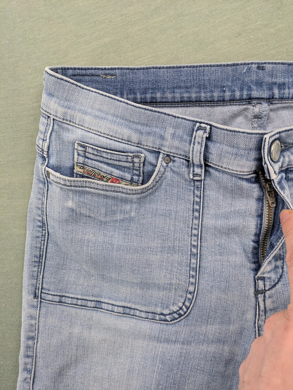 Diesel blue bootcut jeans with white patch pockets and regular waist, stylish stretch material.