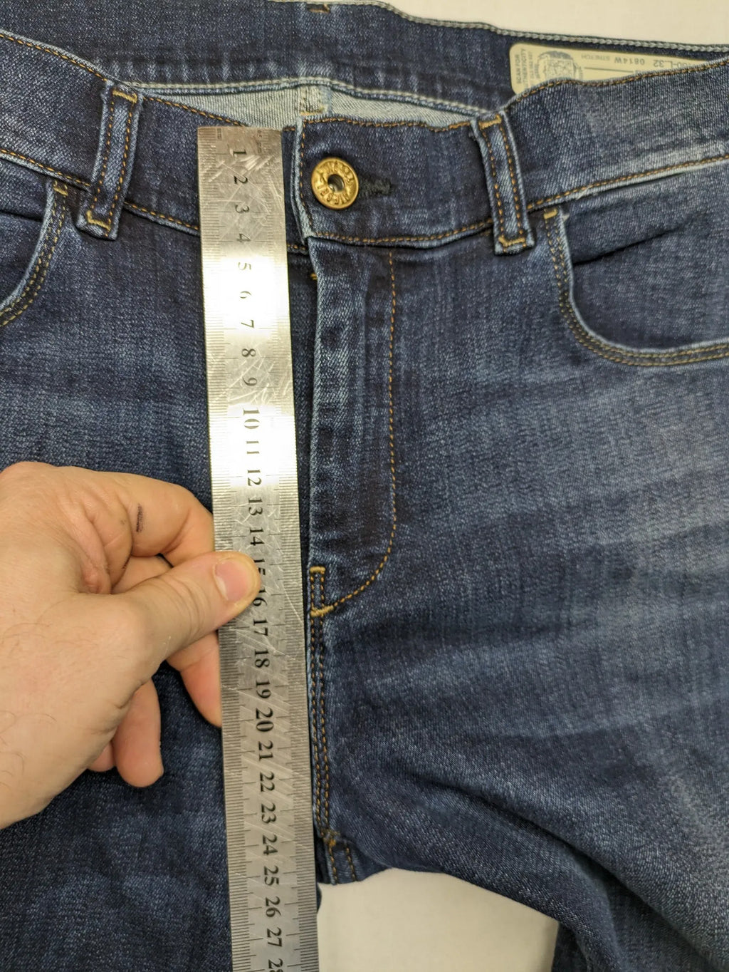 Diesel blue straight jeans with regular waist, dark wash, and stretch material.