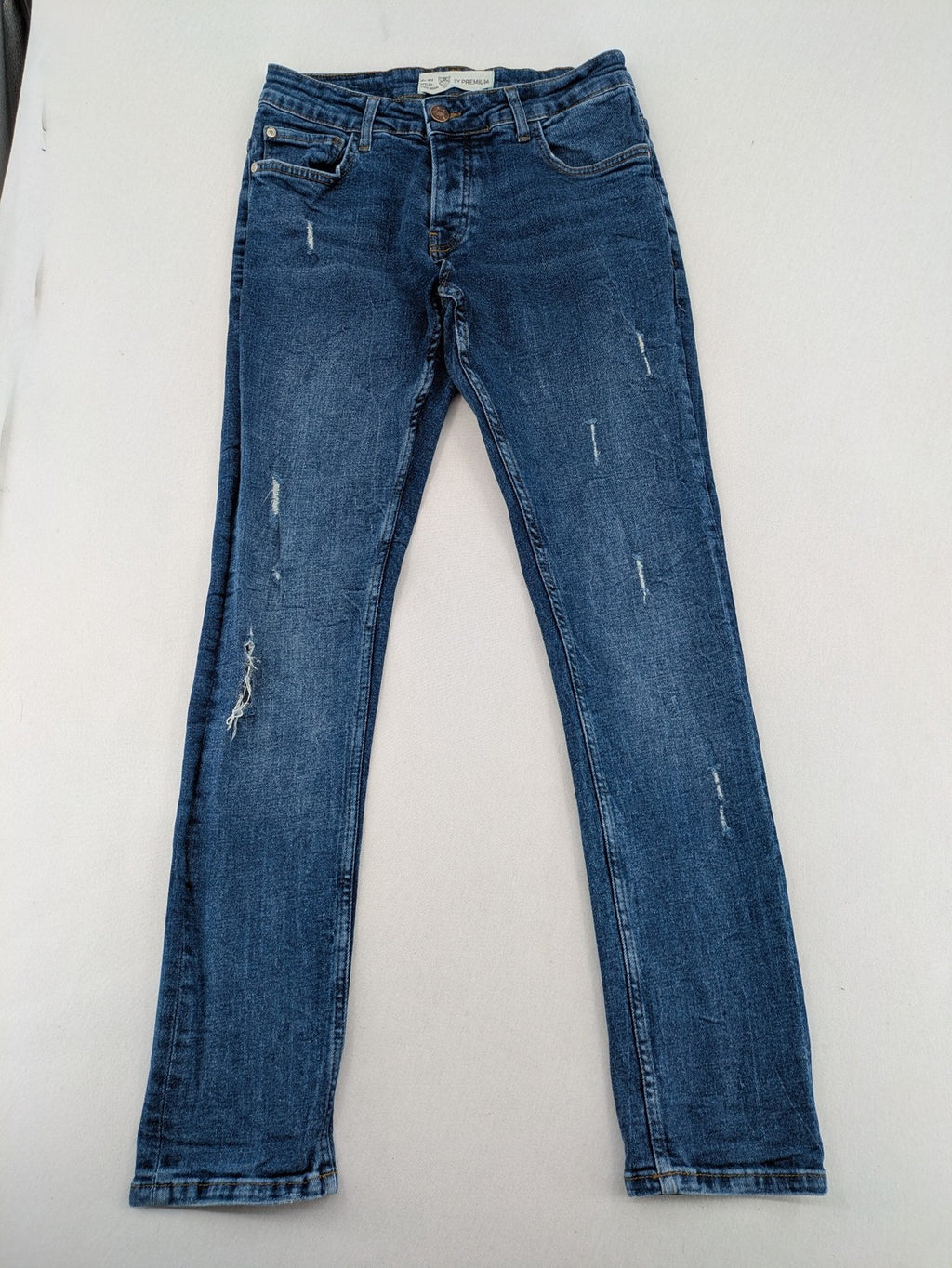 2Y Premium blue skinny jeans with distressed details and classic button fly.