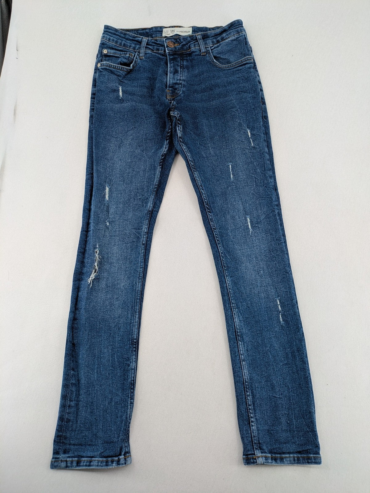 2Y Premium blue skinny jeans with distressed details and classic button fly.