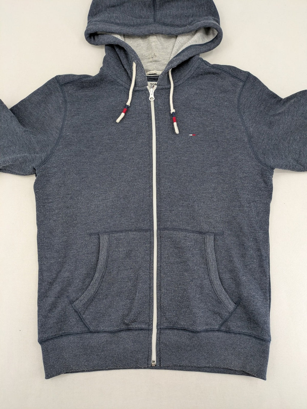 Tommy Jeans blue full zip hoodie with logo, adjustable hood, and kangaroo pockets.