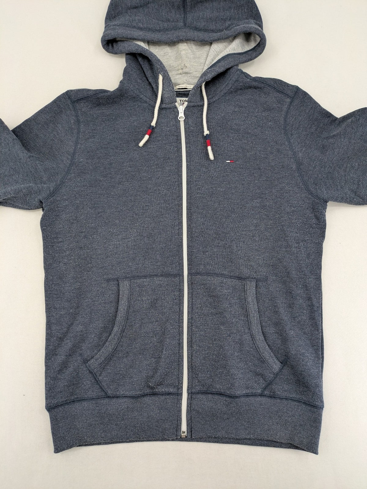 Tommy Jeans blue full zip hoodie with logo, adjustable hood, and kangaroo pockets.