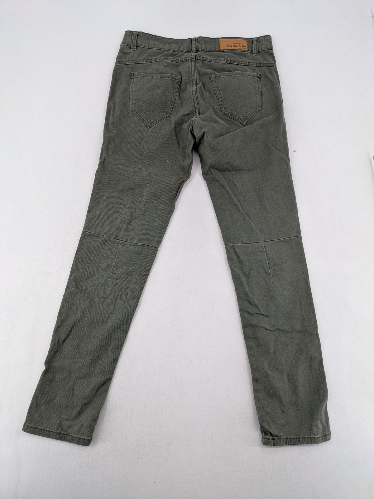 Page One Young khaki motorcycle pants with stitched panels and decorative zipper details.