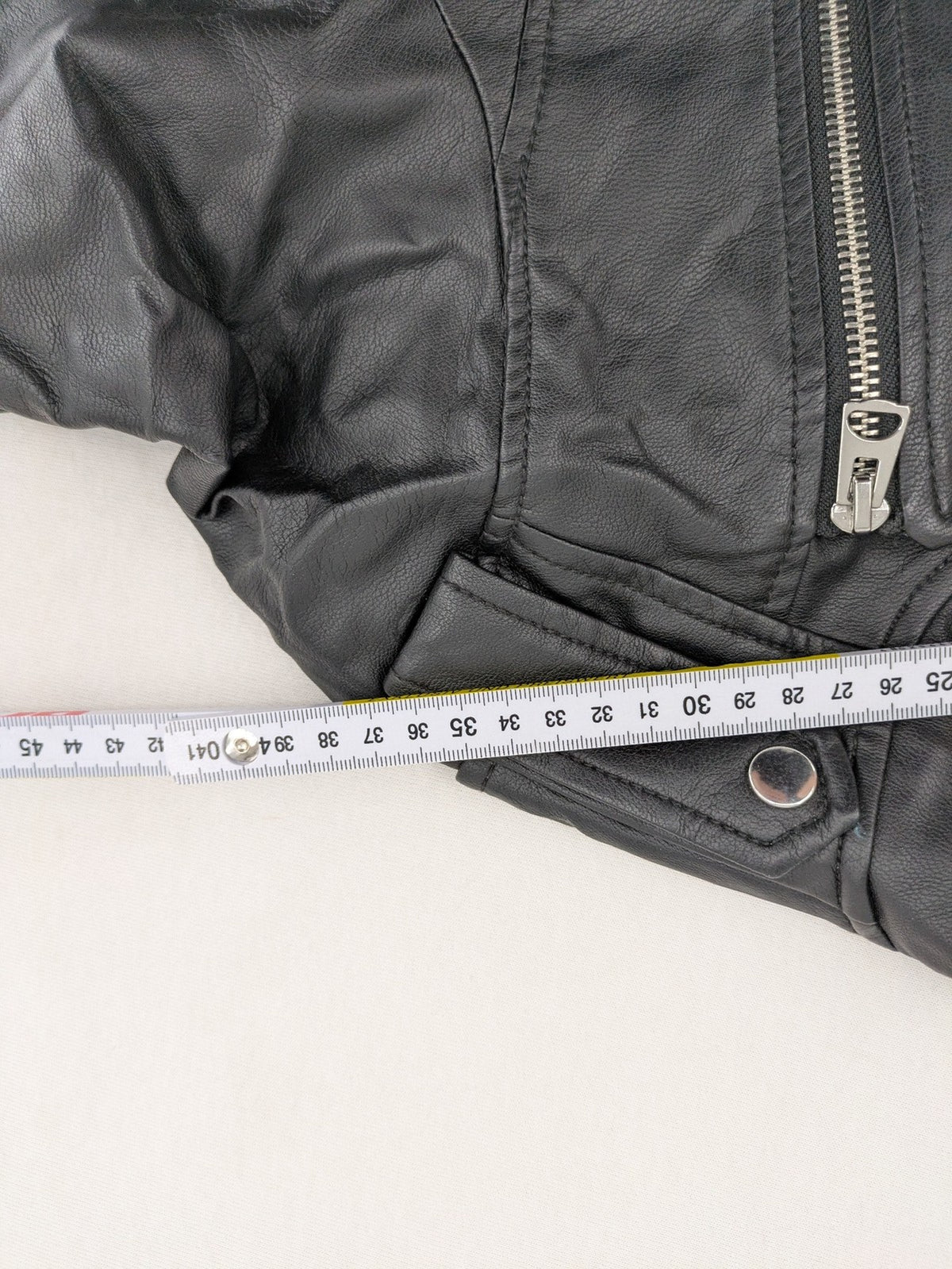 H&M black biker jacket with silver zippers, shoulder flaps, and snap-button details.
