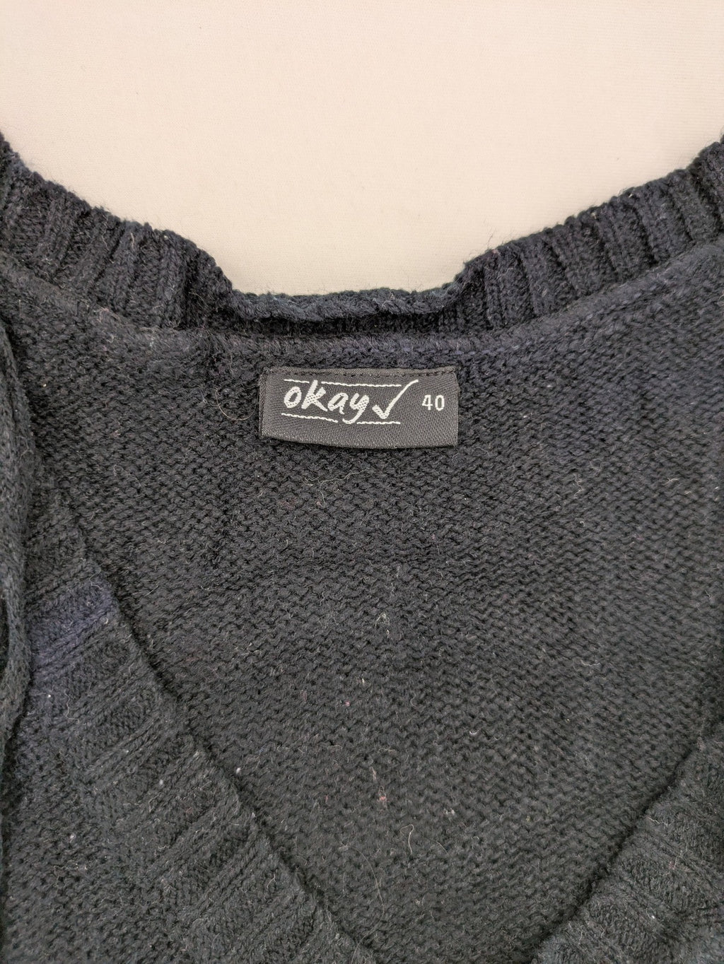 Okay black sleeveless dress V-neck with decorative cord and cable knit pattern.