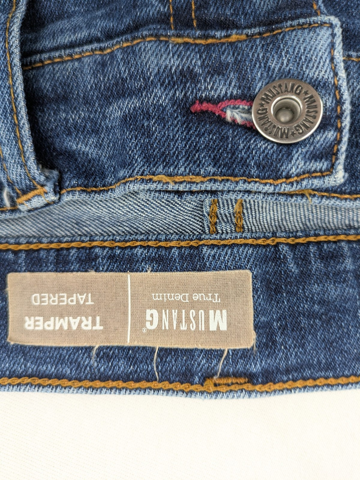 Mustang blue tapered jeans with slim fit, medium rise, and classic denim texture.