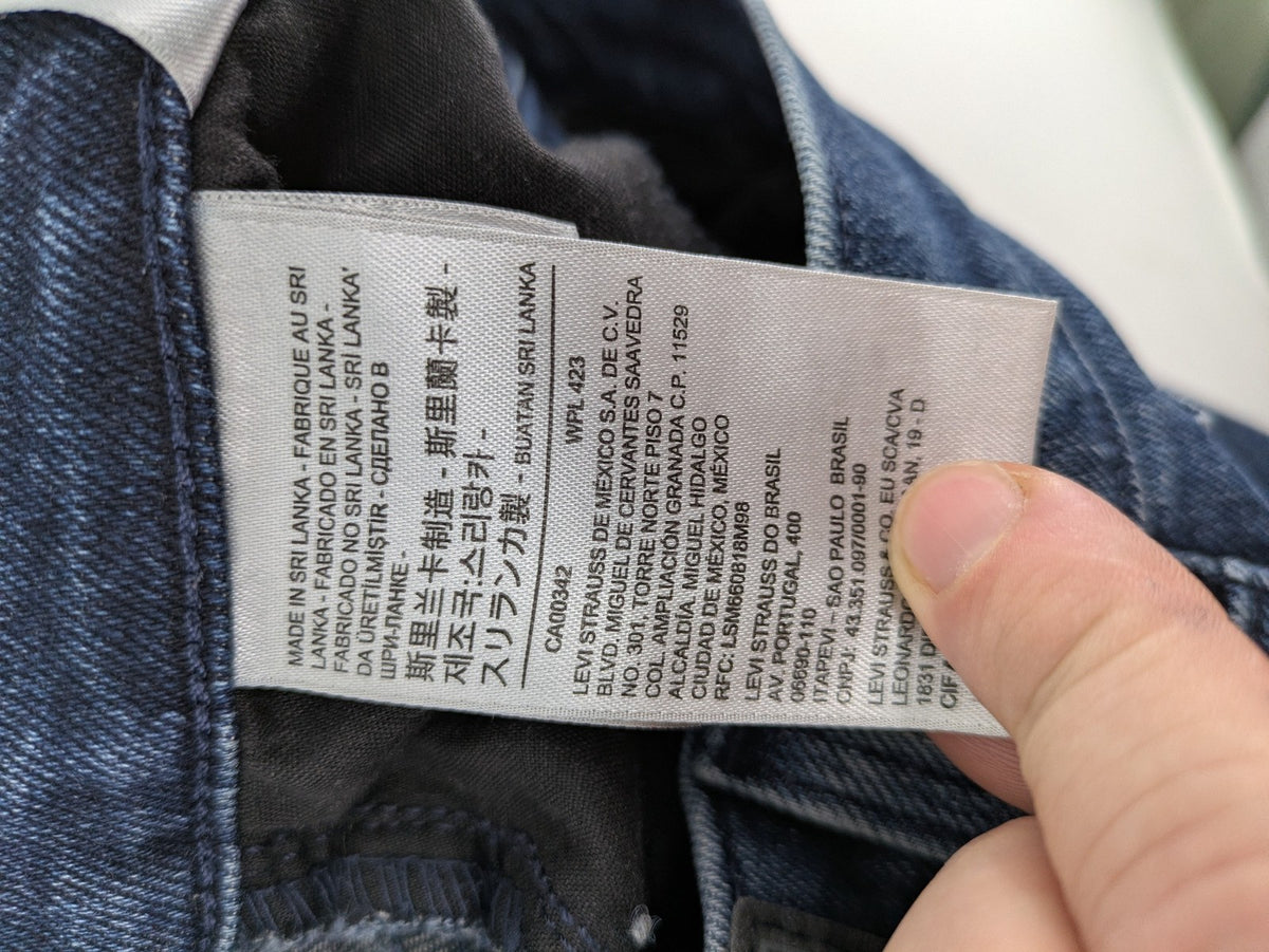 Levi's high waisted taper jeans dark blue 5-pocket design with zipper and stretch material.