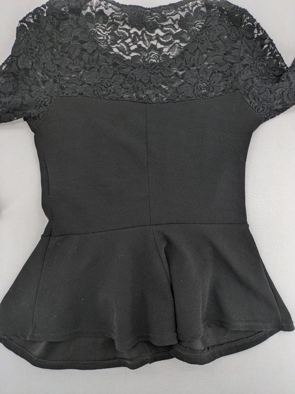 Amisu black peplum top with floral lace sleeves and delicate lace trim.