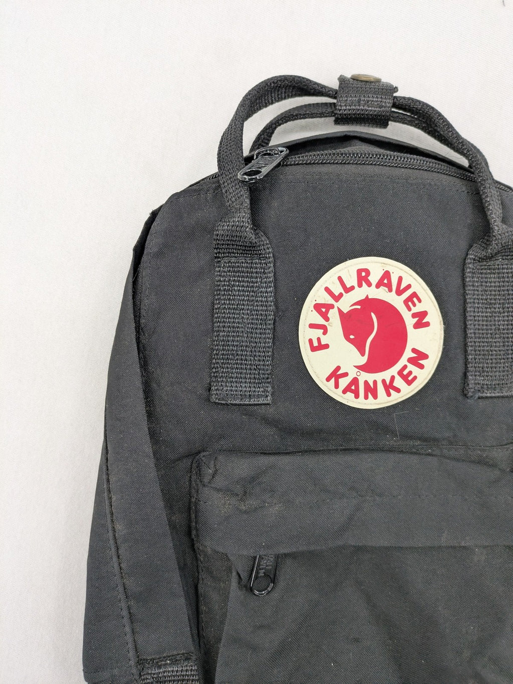 Fjällräven Kånken Mini rucksack black durable fabric with logo and zippered main compartment.