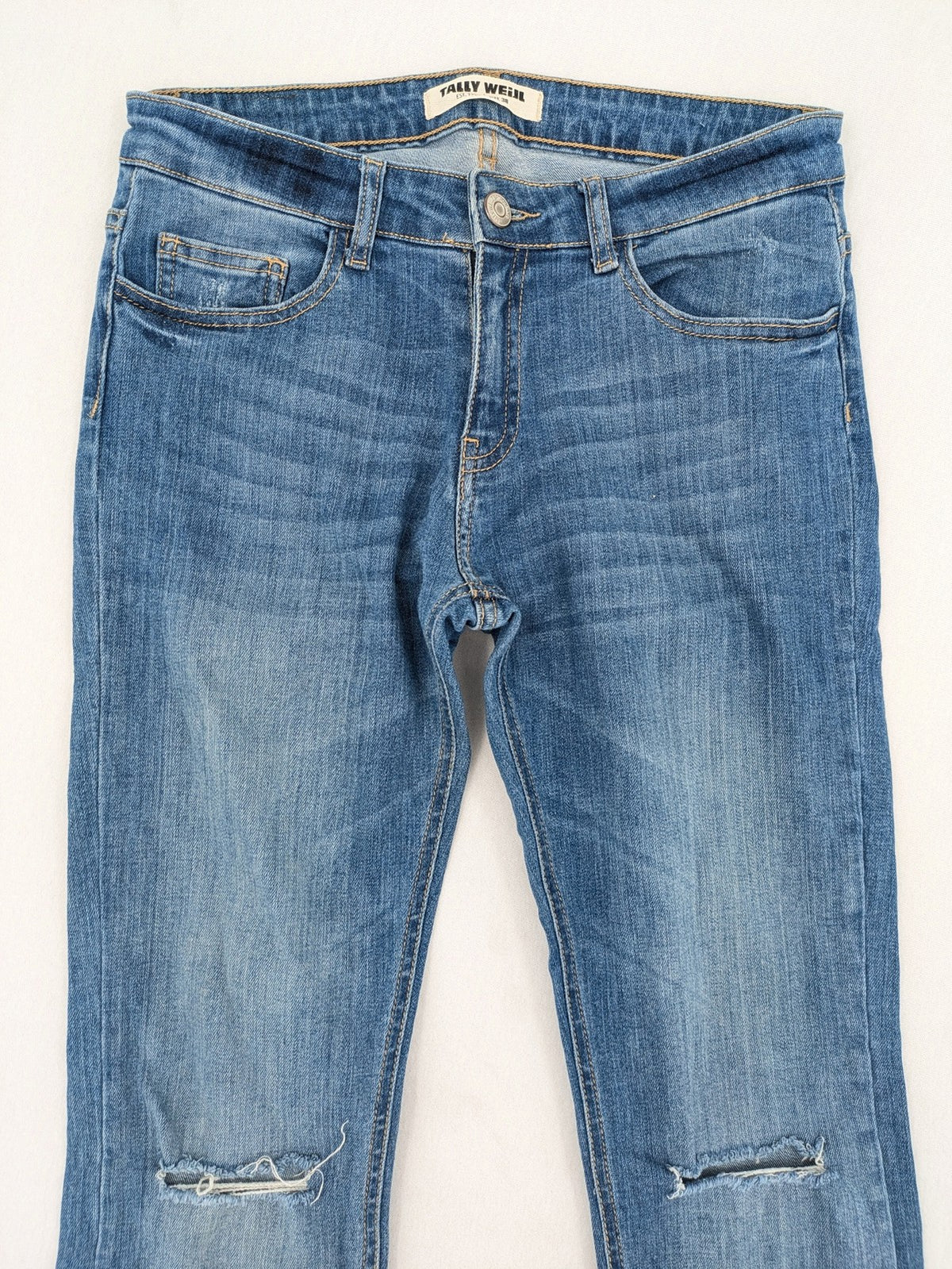 Tally Weijl blue bootcut jeans with distressed knees and raw hem detail.