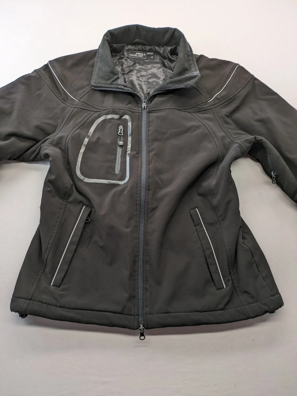 James & Nicholson grey softshell jacket with fleece lining and multiple zip pockets.