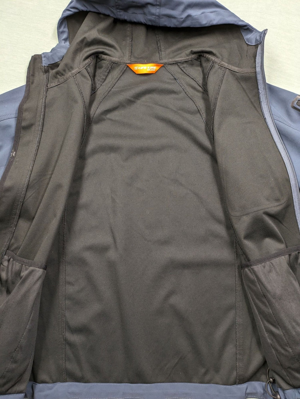 Life Line grey softshell jacket with adjustable hood and durable wind-resistant material.
