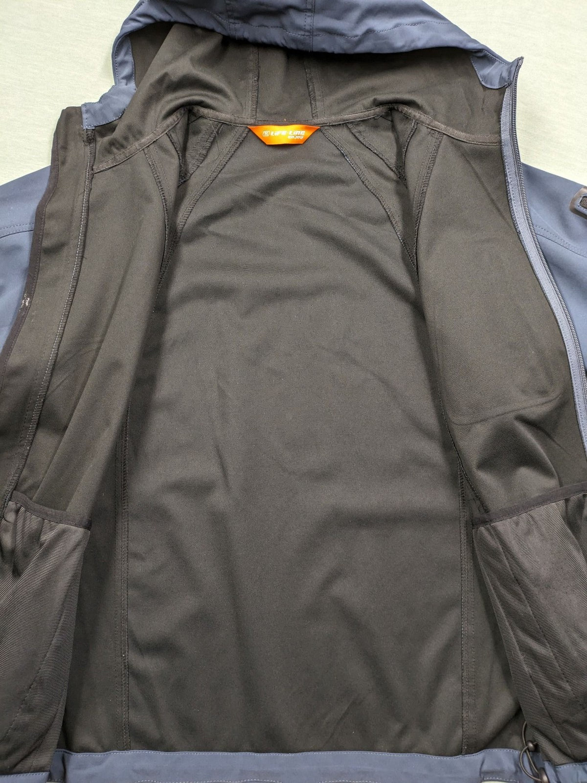 Life Line grey softshell jacket with adjustable hood and durable wind-resistant material.