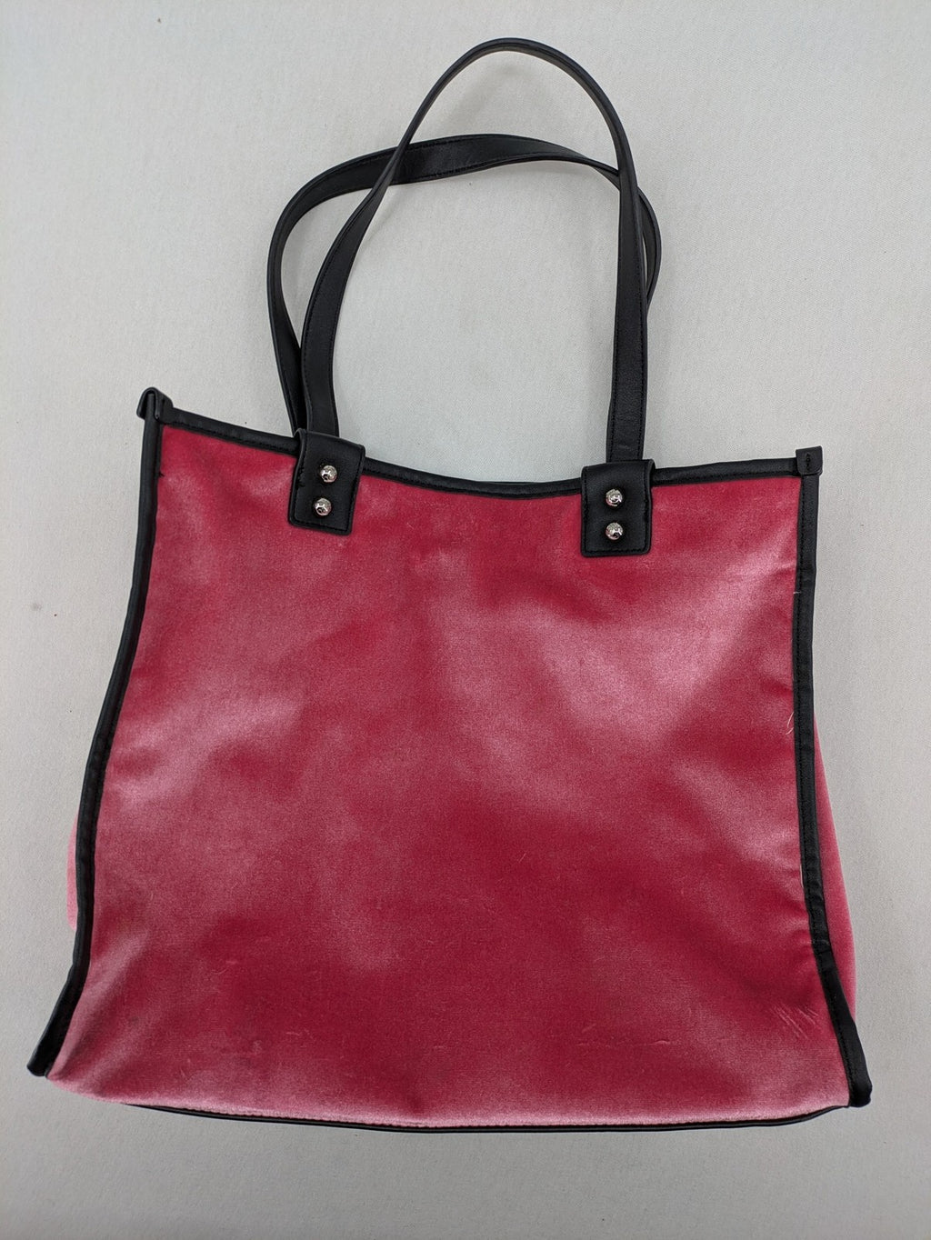 Juicy Couture pink velour handbag with oversized black logo and faux leather straps.