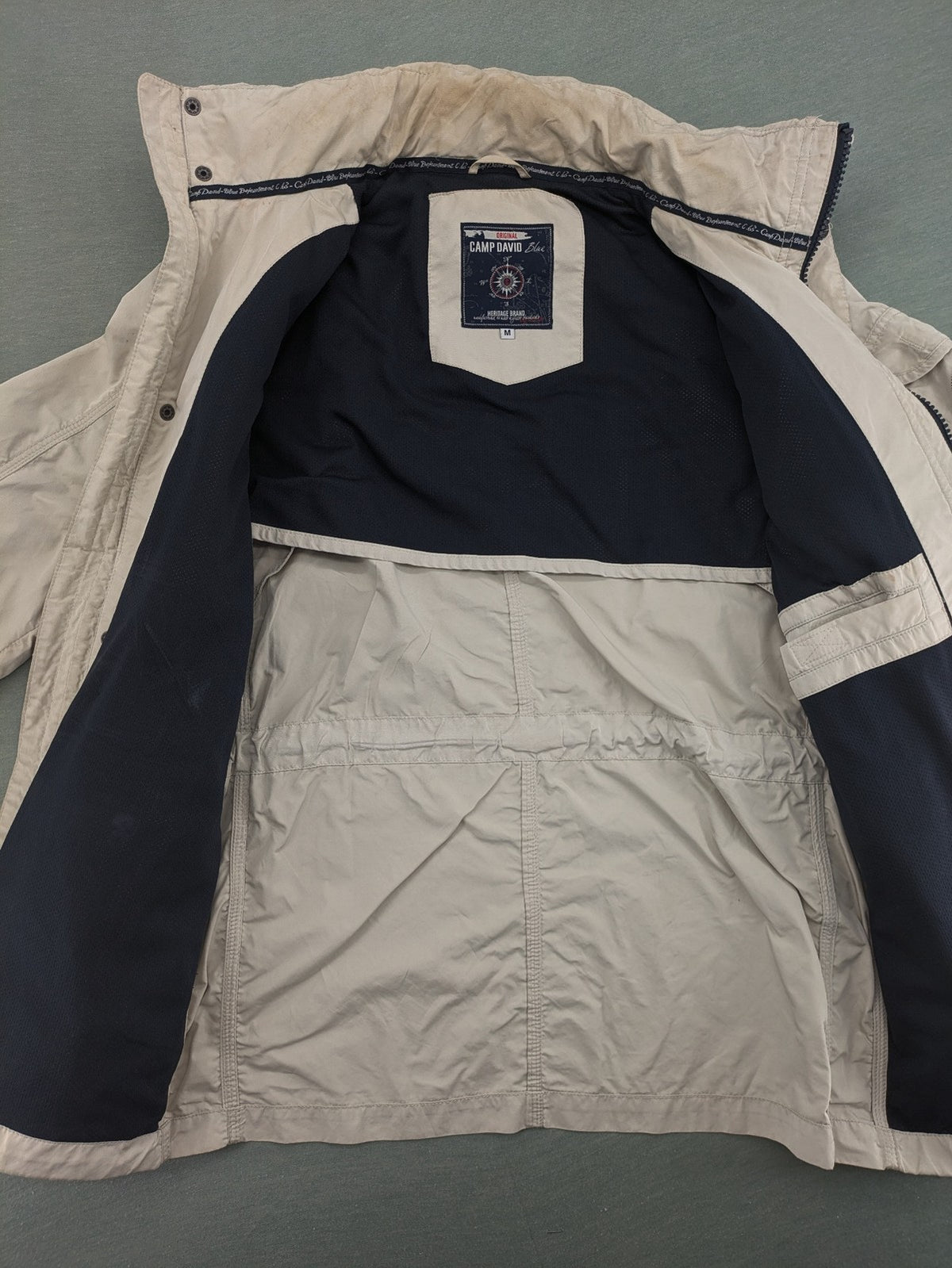 Camp David beige field jacket with logo patches, standing collar, and multiple pockets.