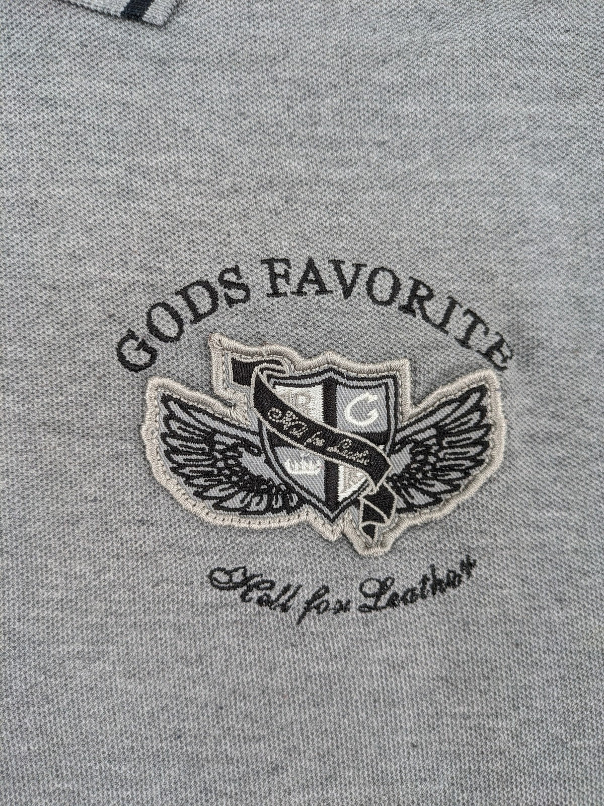 Götter & Helden grey polo shirt with "Gods Favorite" embroidery and contrasting collar details.
