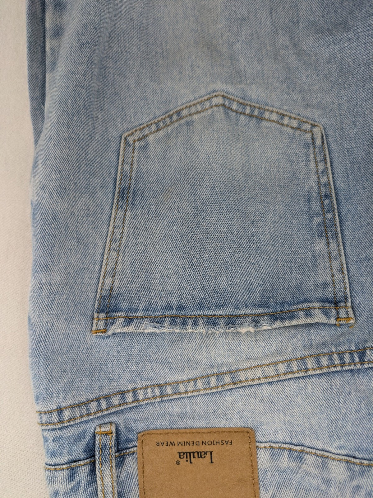 Laulia blue wide leg jeans with distressed knee rips and high waist design.