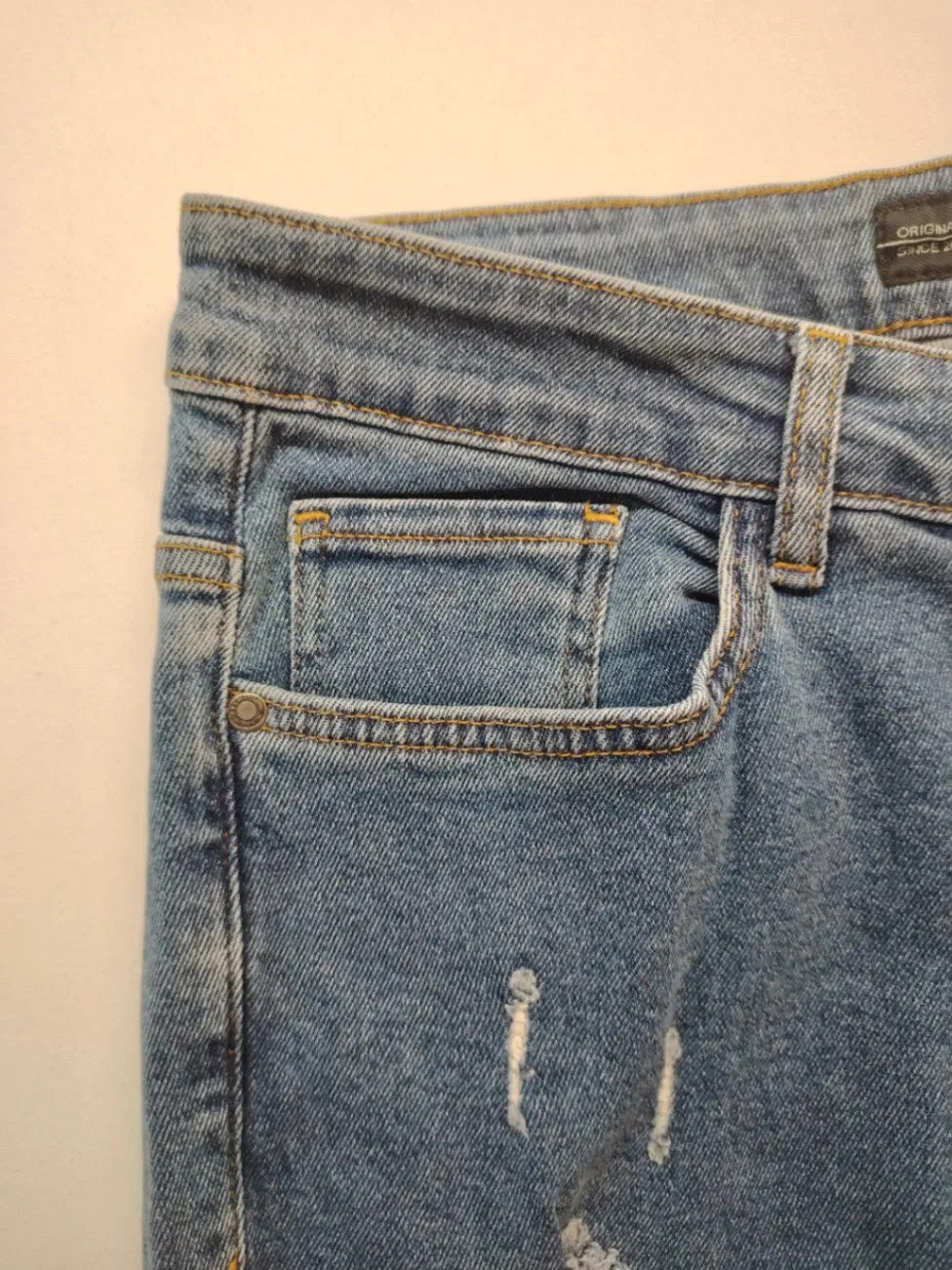 Damen blue skinny jeans with ripped details, five-pocket style, and classic button closure.