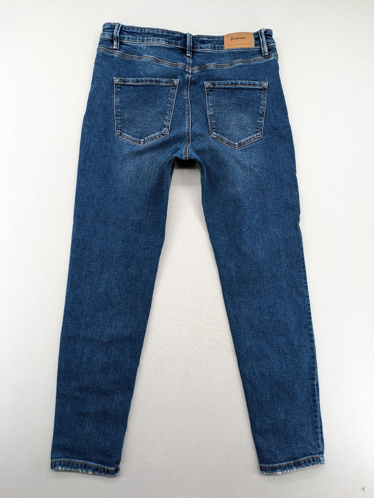 Stradivarius blue low waist skinny jeans with subtle fading and classic denim texture.