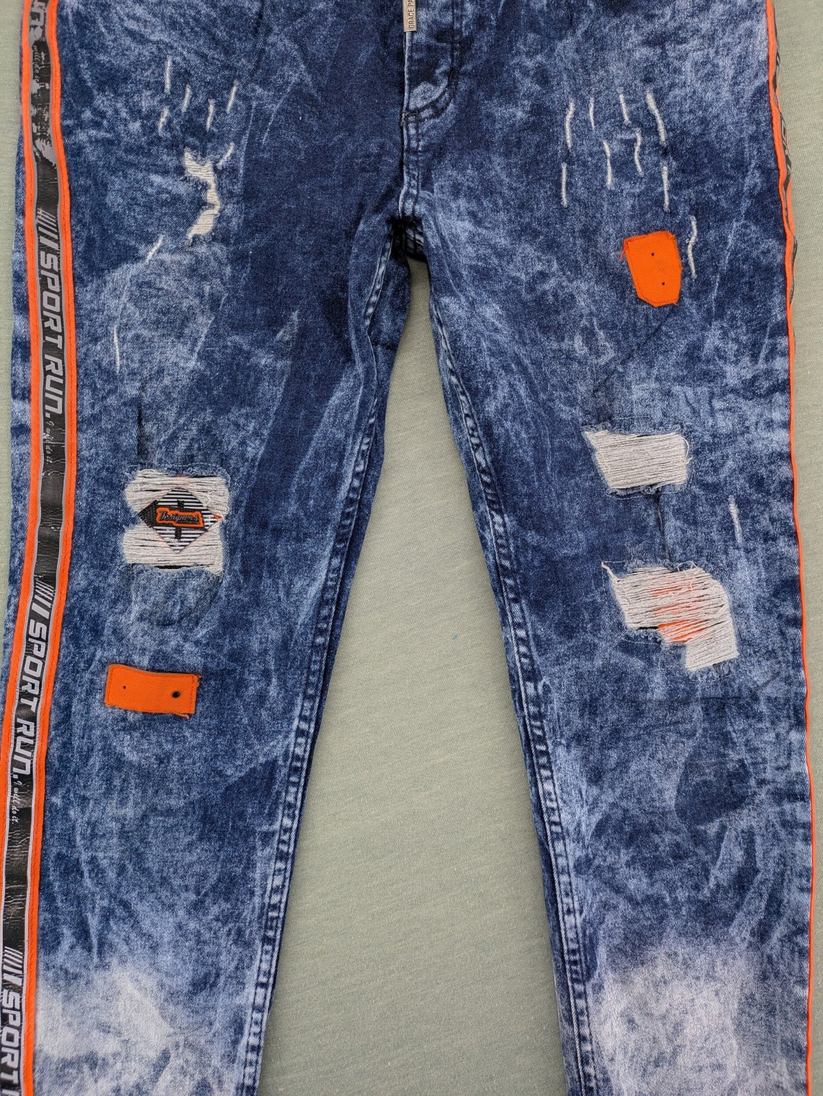 Stark straight jeans multi distressed acid wash with orange patches and side stripes.
