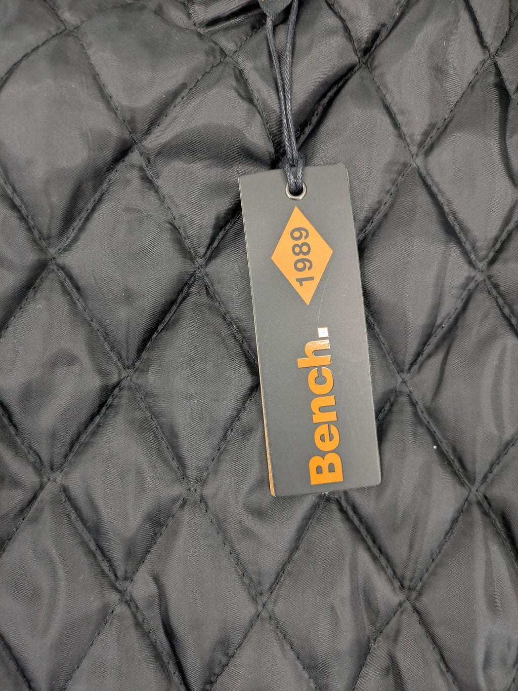 Bench cream flannel jacket with check pattern, black hood, and button placket.