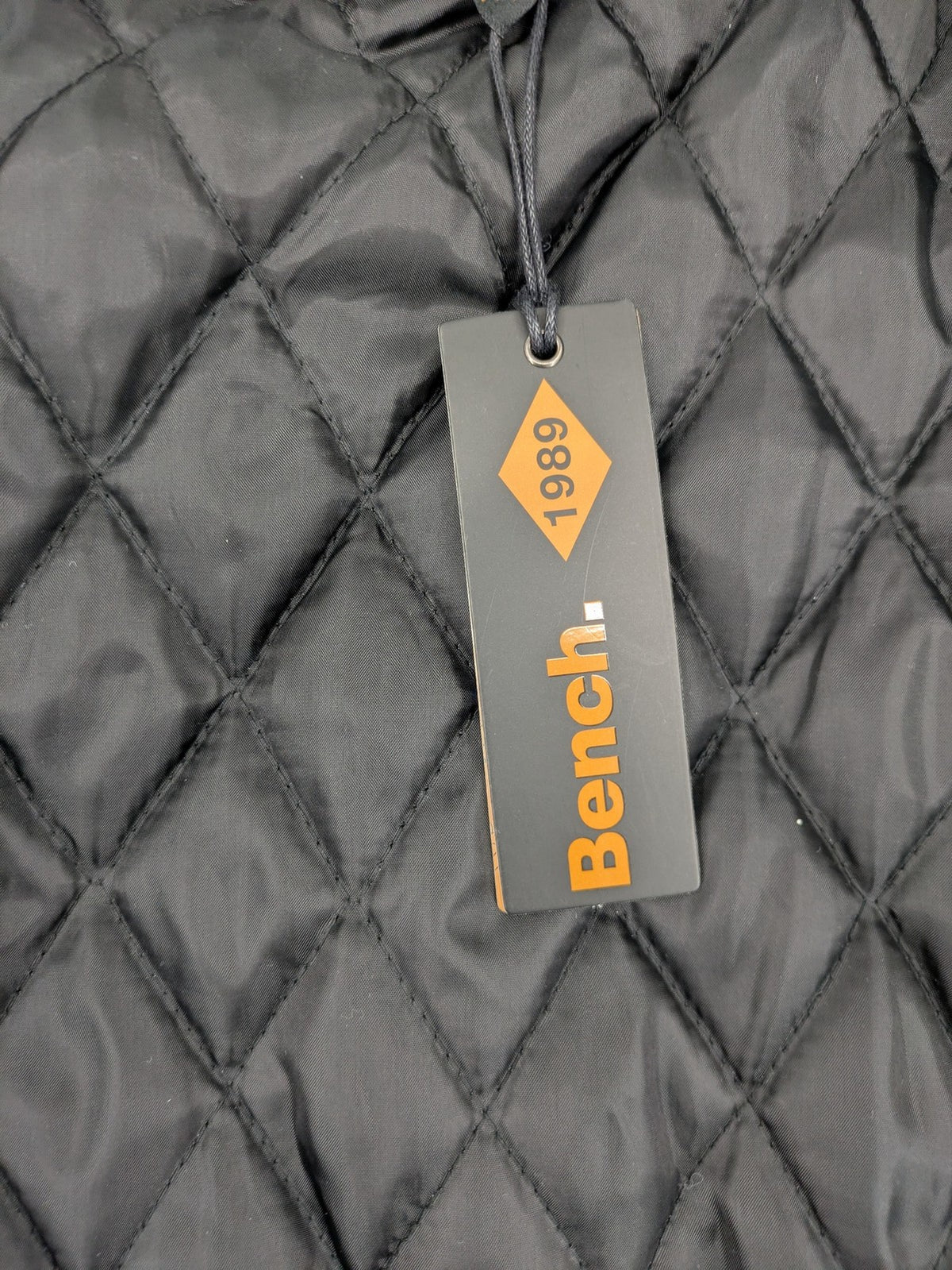 Bench cream flannel jacket with check pattern, black hood, and button placket.