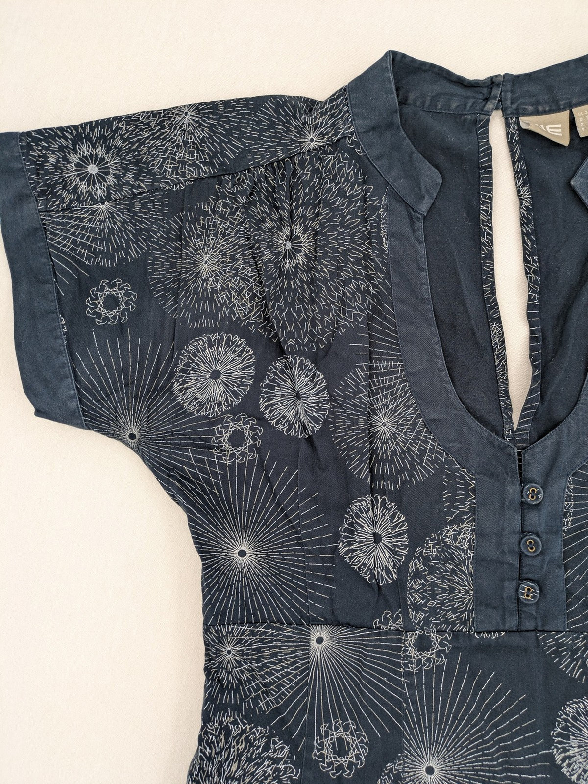 Muster navy dress with white abstract dandelion print, V-neck and collar details.