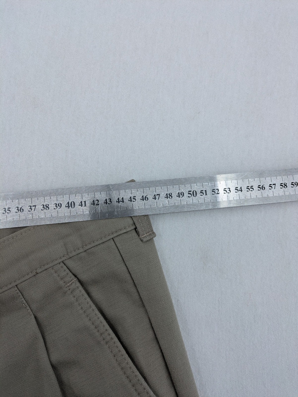 Pioneer beige chino trousers with pleats, straight leg, and buttoned back pocket.