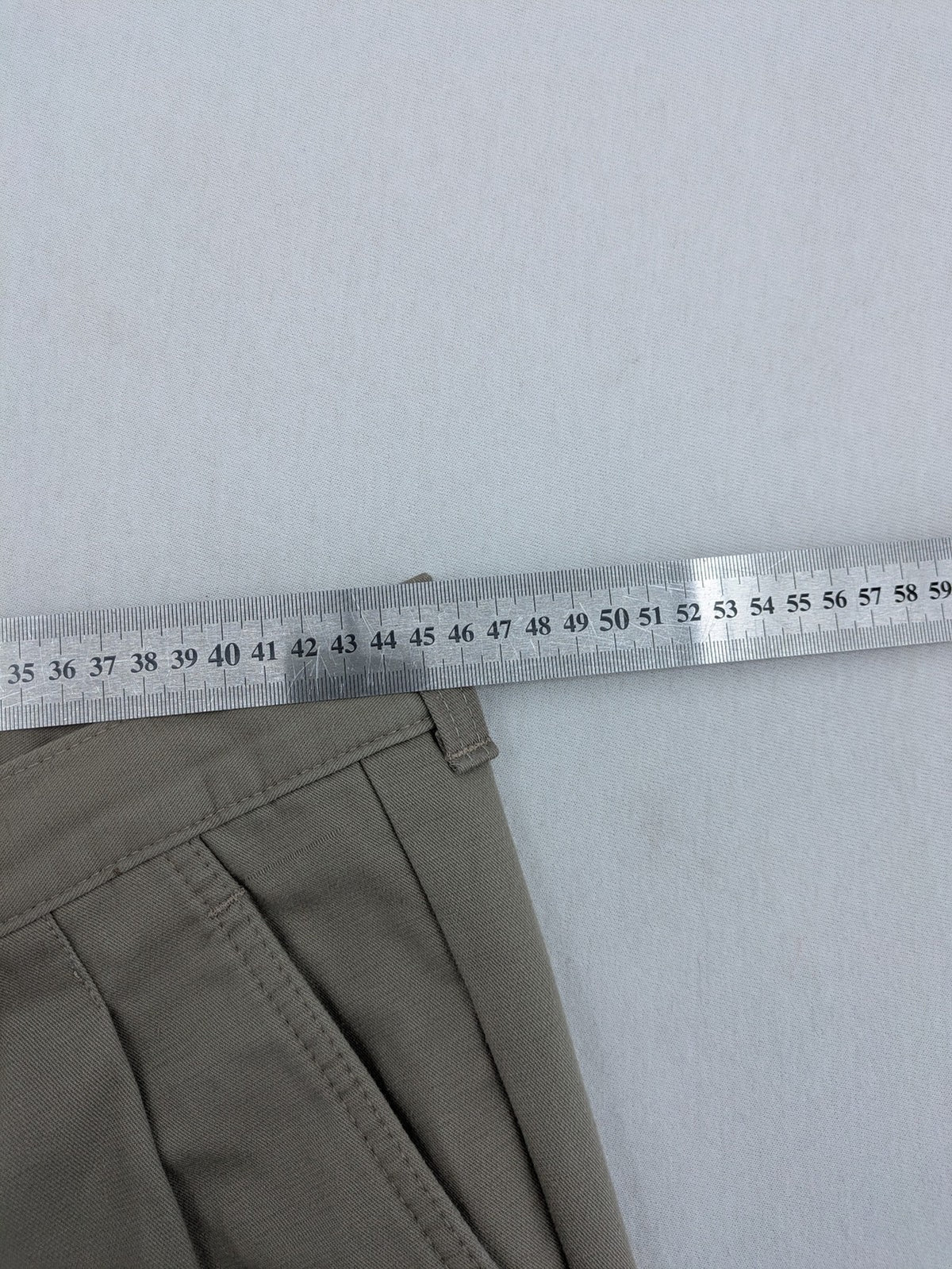 Pioneer beige chino trousers with pleats, straight leg, and buttoned back pocket.