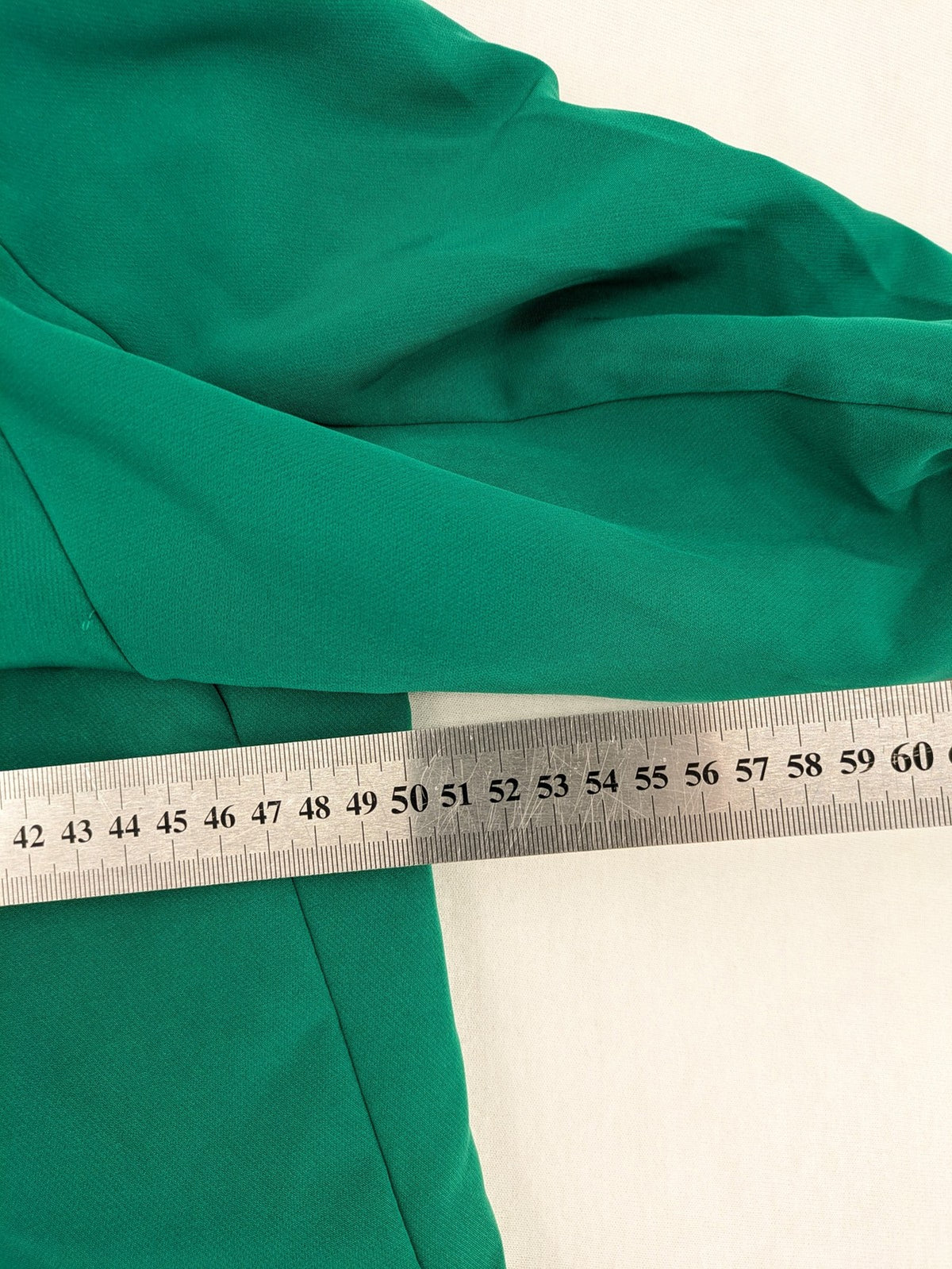 Promiss green blazer jacket single-button design with notch lapels and decorative pockets.