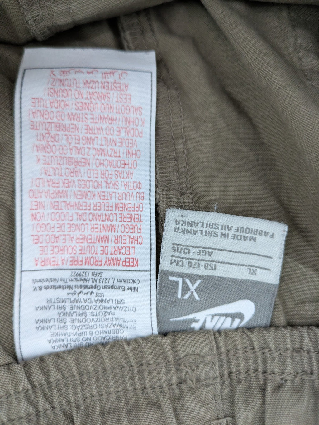 Nike khaki training pants with logo, elastic waistband, and practical pockets.