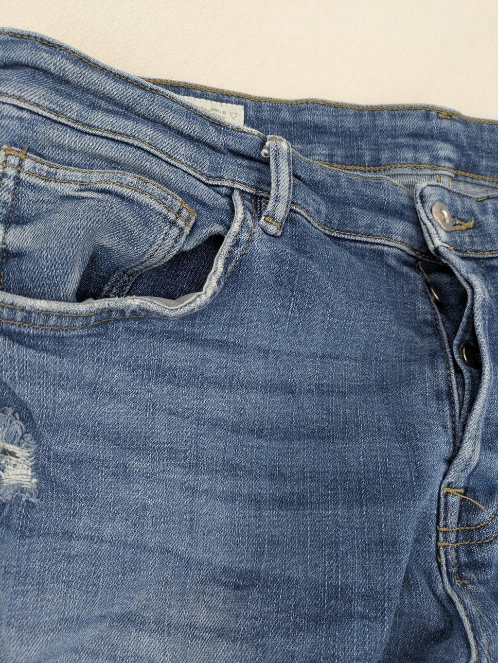 Zara blue straight jeans with distressed ripped knees and button-fly closure.