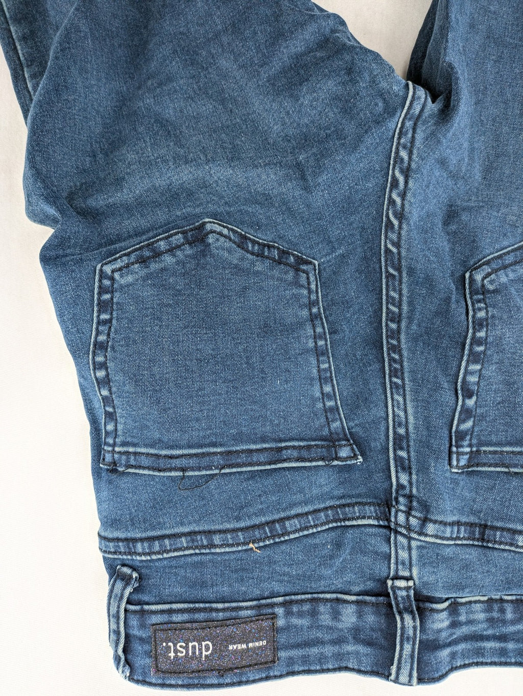 Dust blue skinny jeans with mid-rise waist and classic wash, stretch denim material.