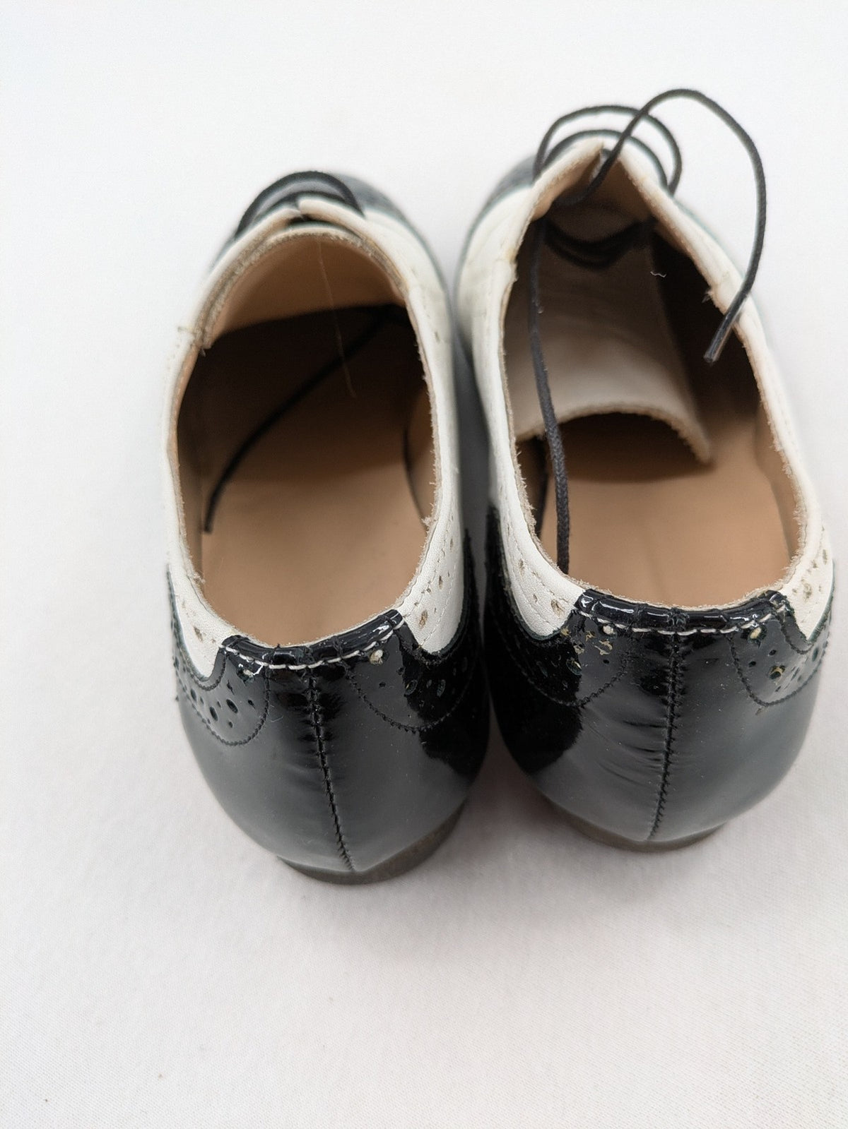 Kontrast black and white deck shoes, glossy patent leather with wingtip cap and brogue detailing.