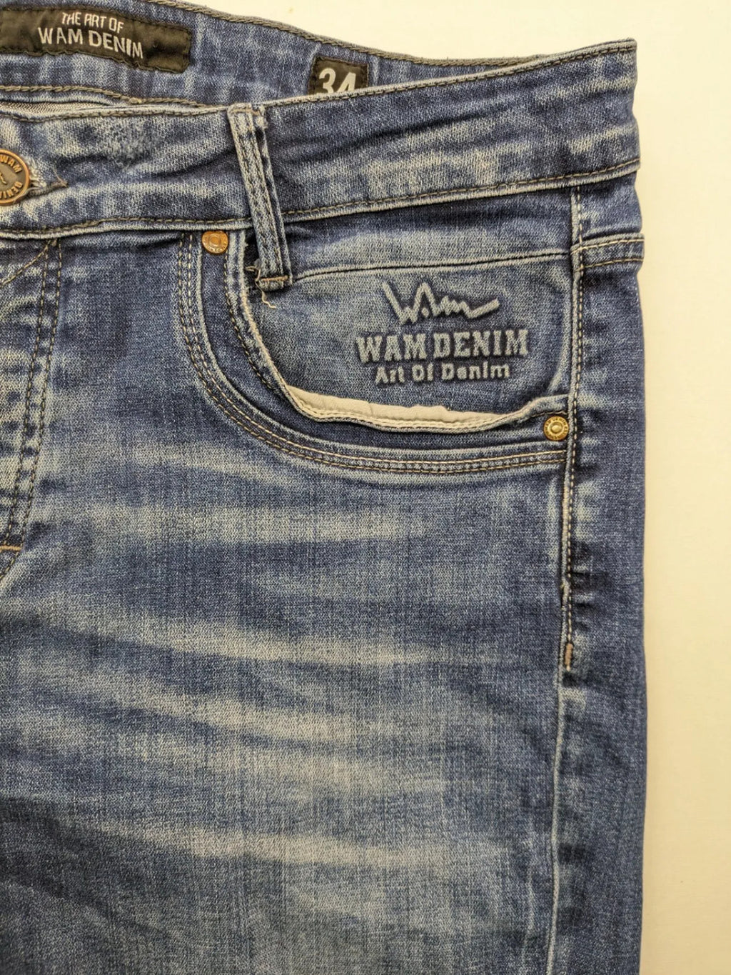 WAM Denim blue straight jeans with distressed details and button fly.