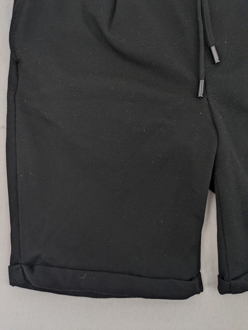Zara black shorts with elastic drawstring, pleats, and rolled hem detail.