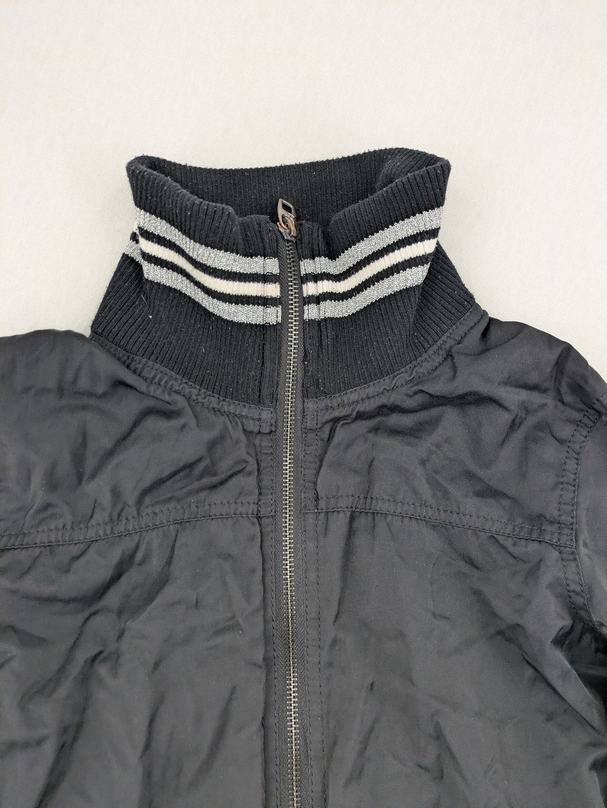 Ann Christine black bomber jacket with striped ribbed collar and cuffs, zip closure.