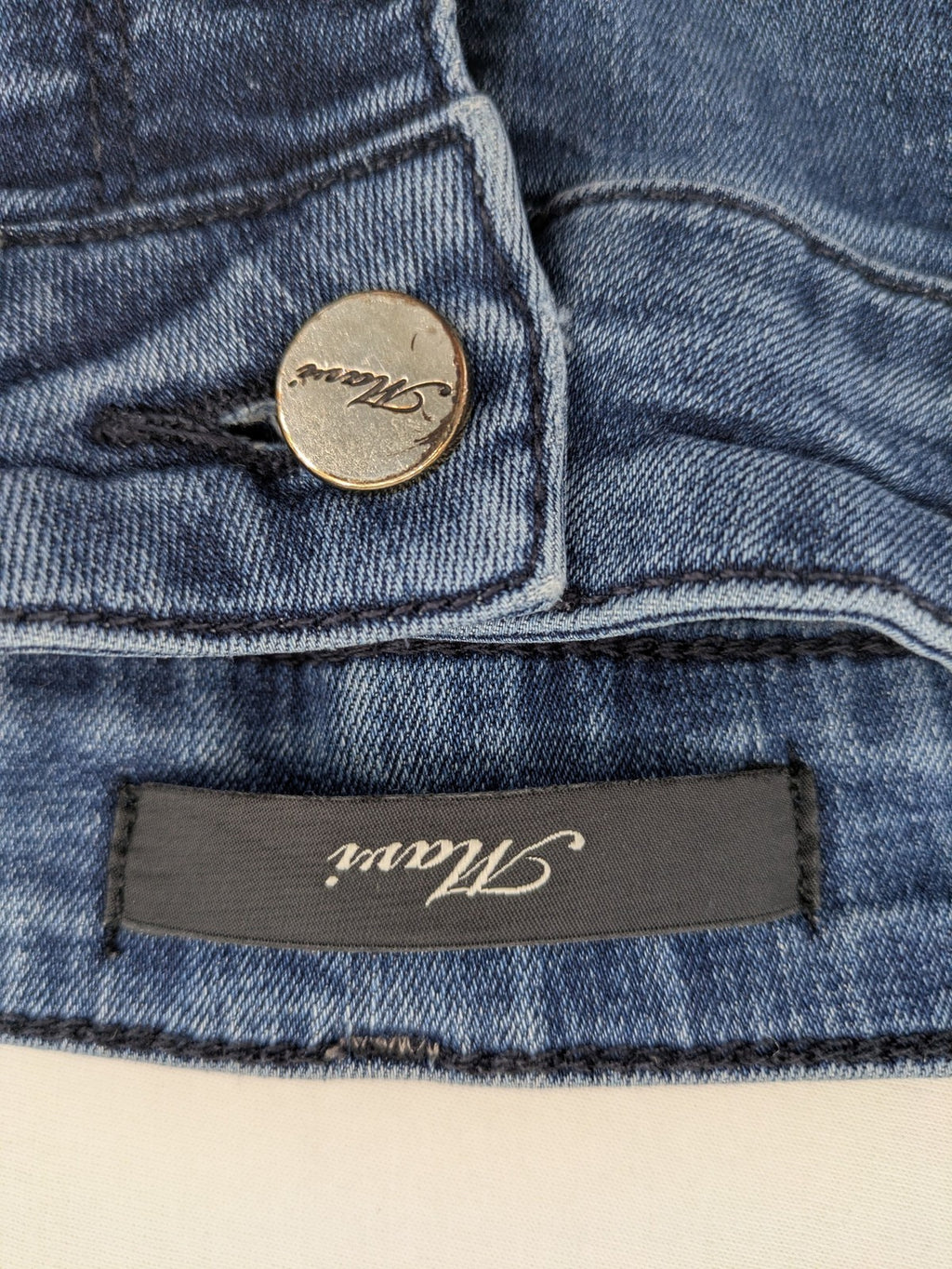 Mavi blue high rise super skinny jeans with medium wash and stretch denim material.