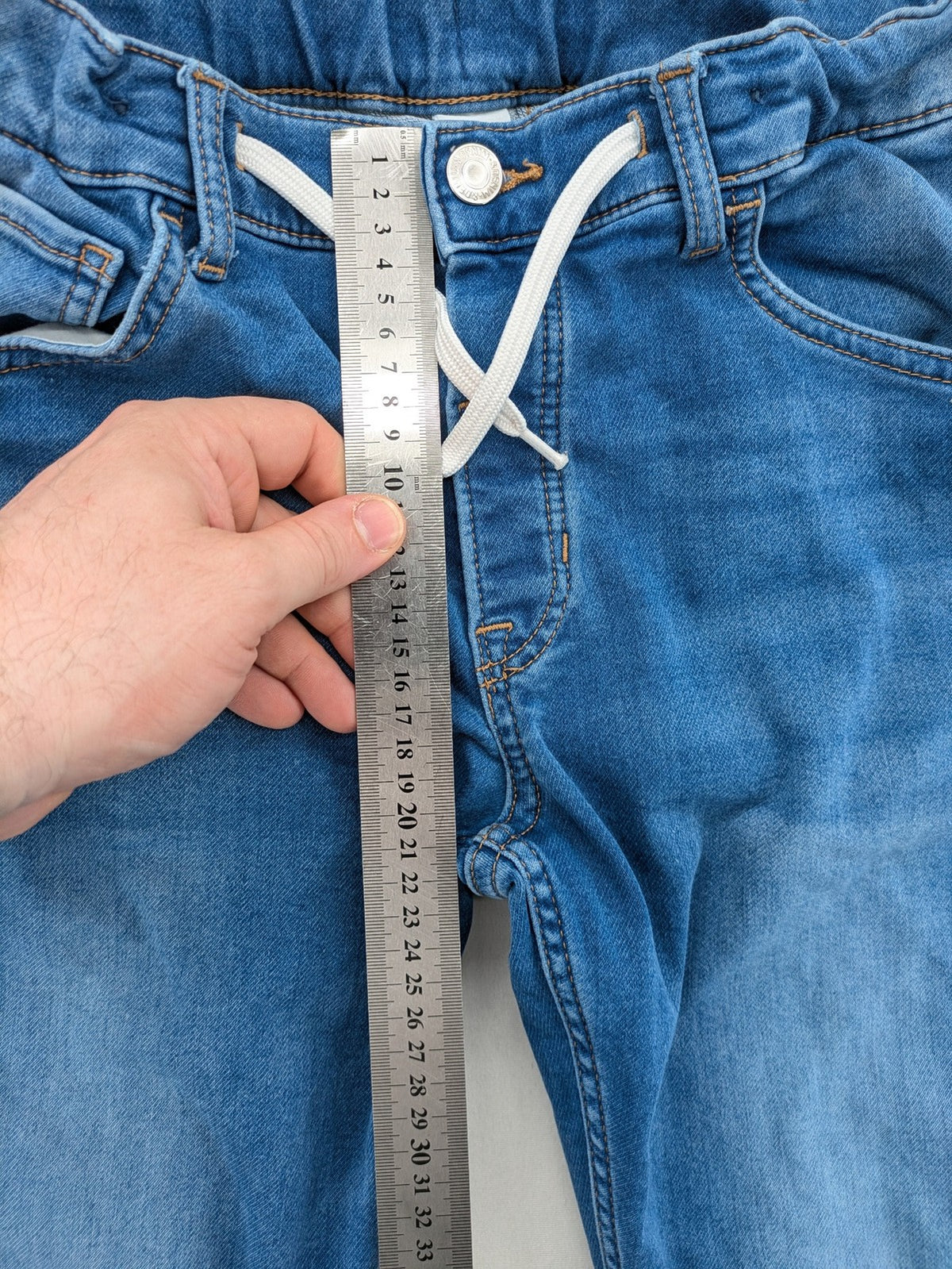 H&M blue straight jeans with elastic waistband and white drawstring, casual jogger style.