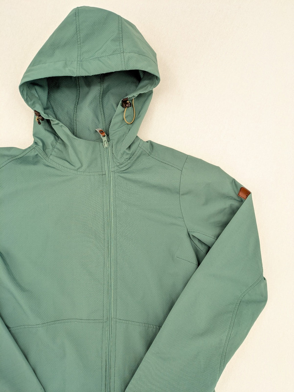 Frilufts green softshell jacket with hood, longline design, durable zipper, practical zip pockets.