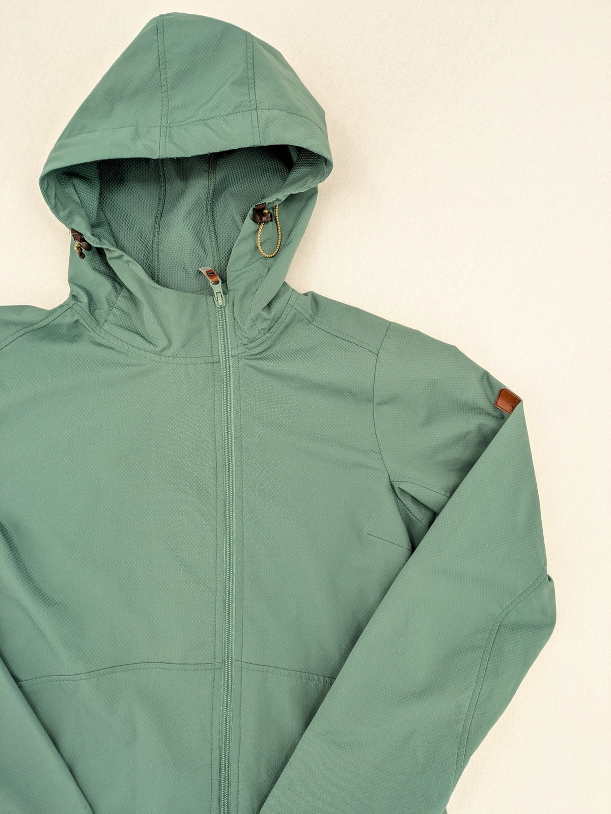 Frilufts green softshell jacket with hood, longline design, durable zipper, practical zip pockets.